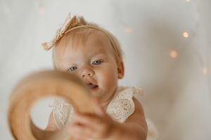 A baby in soft lighting with a dreamy blurred motion effect and bokeh lights in the background.
