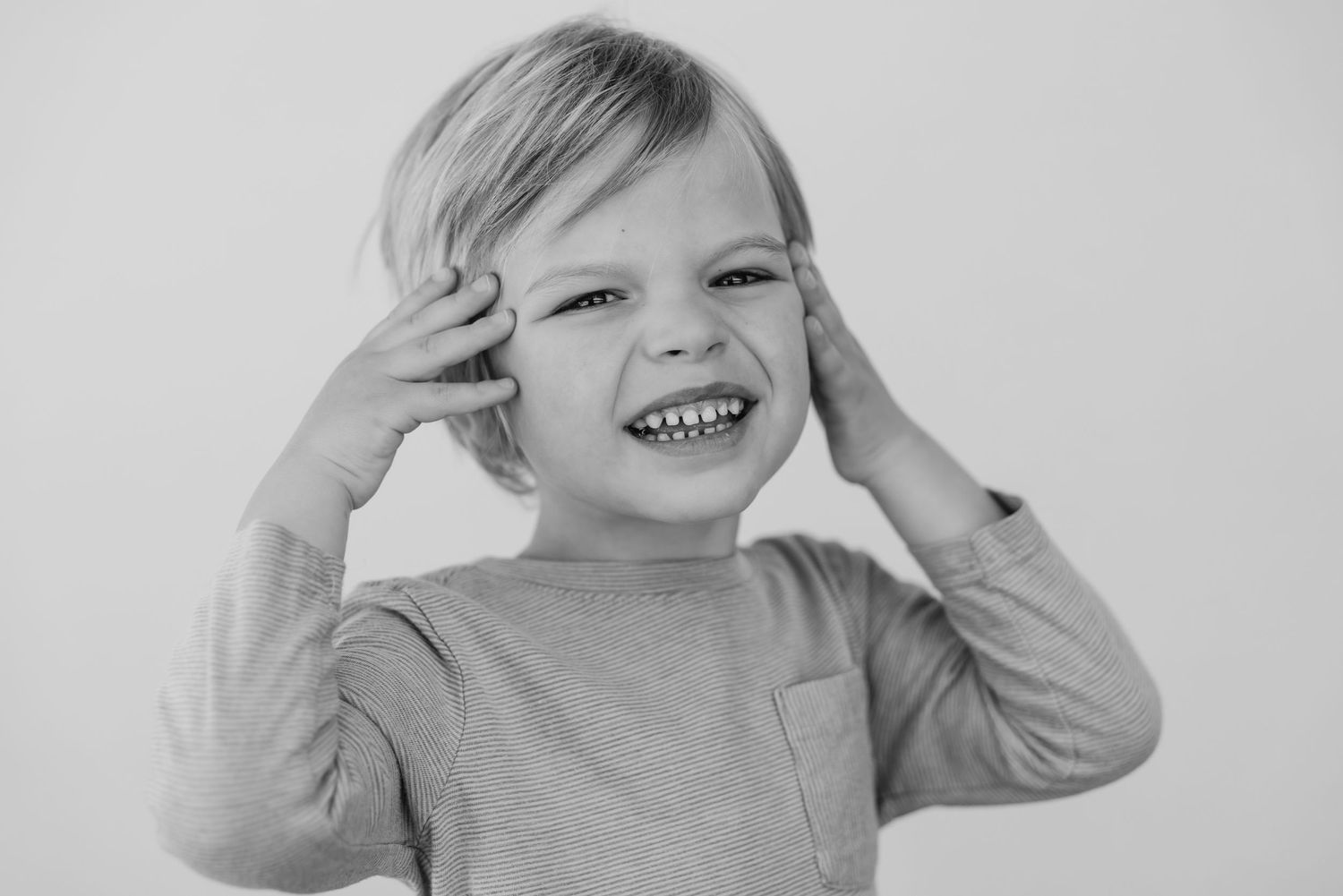 Black and white portrait series showing a child's expressions ranging from serious to joyful.