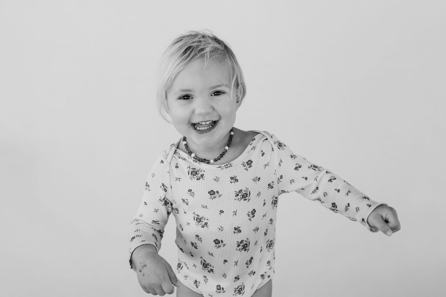 Black and white portrait series showing a child's expressions ranging from serious to joyful.
