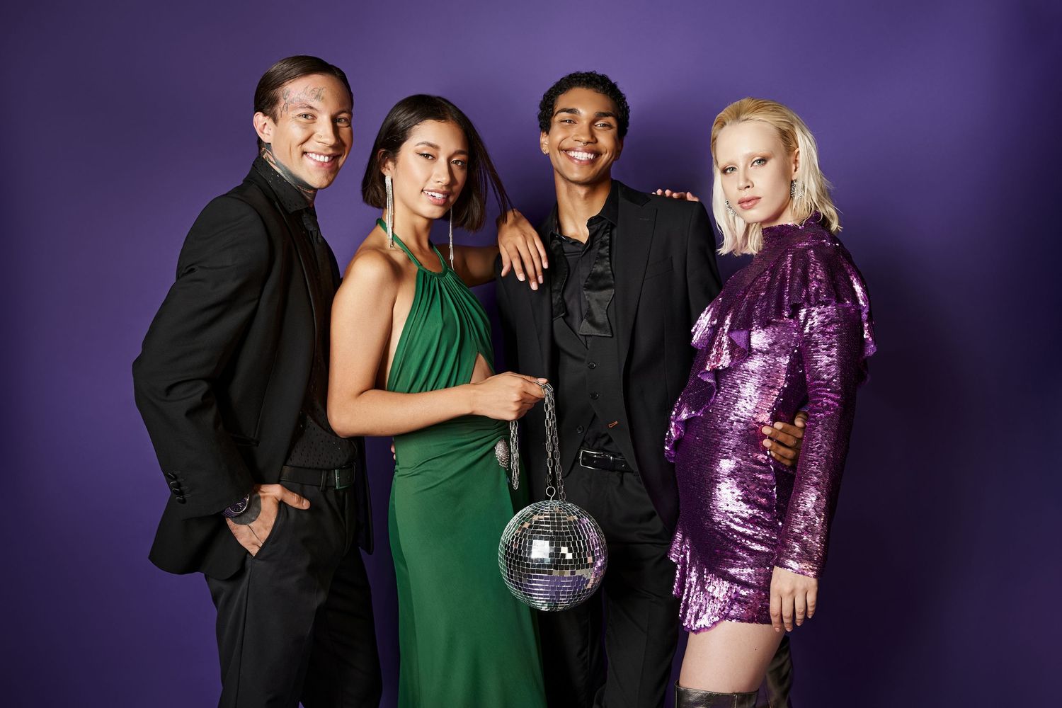 Group poses in stylish outfits against a deep purple backdrop with disco ball lighting effects creating a party atmosphere.