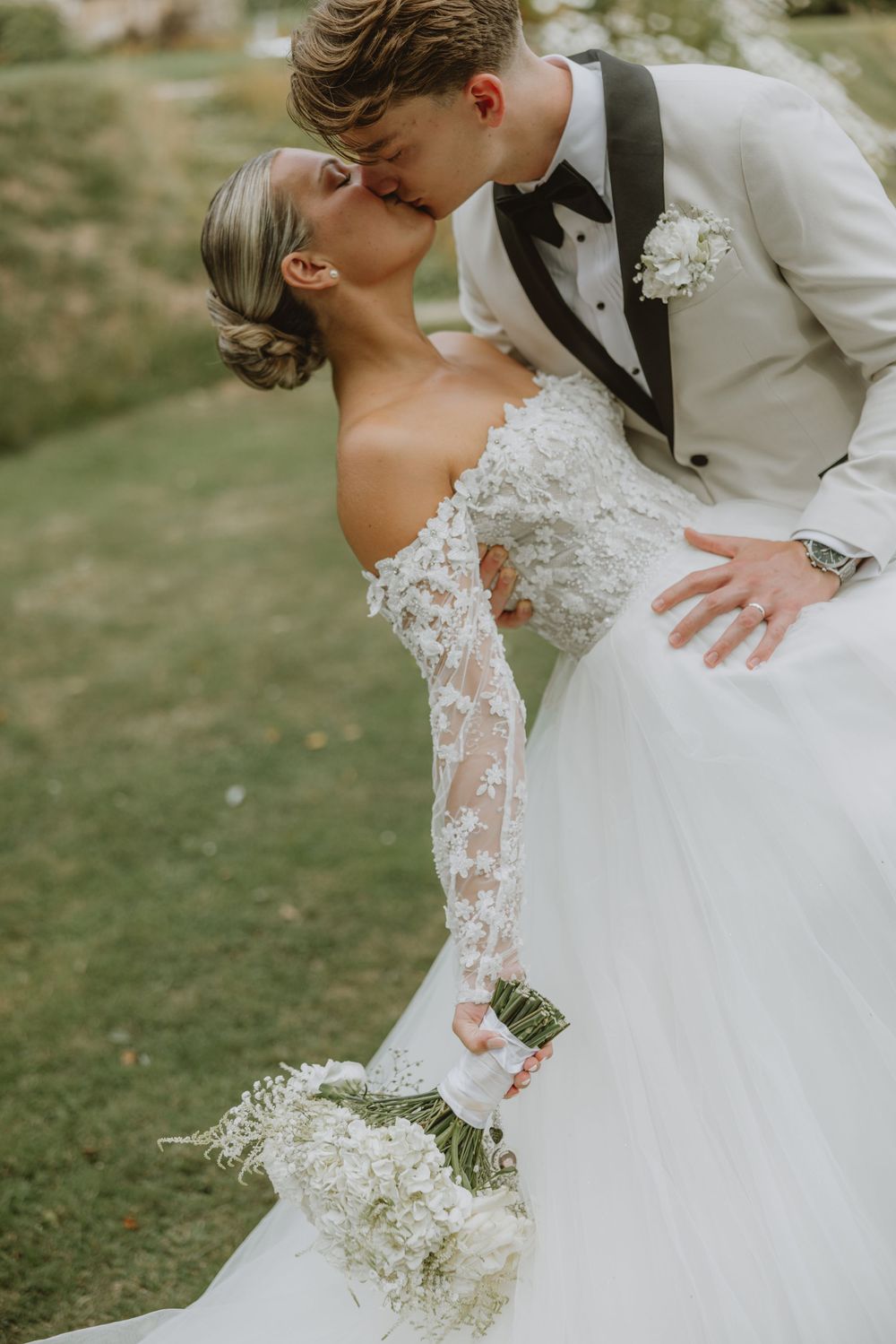 A romantic wedding moment captured outdoors with the couple in an intimate pose against a natural backdrop.