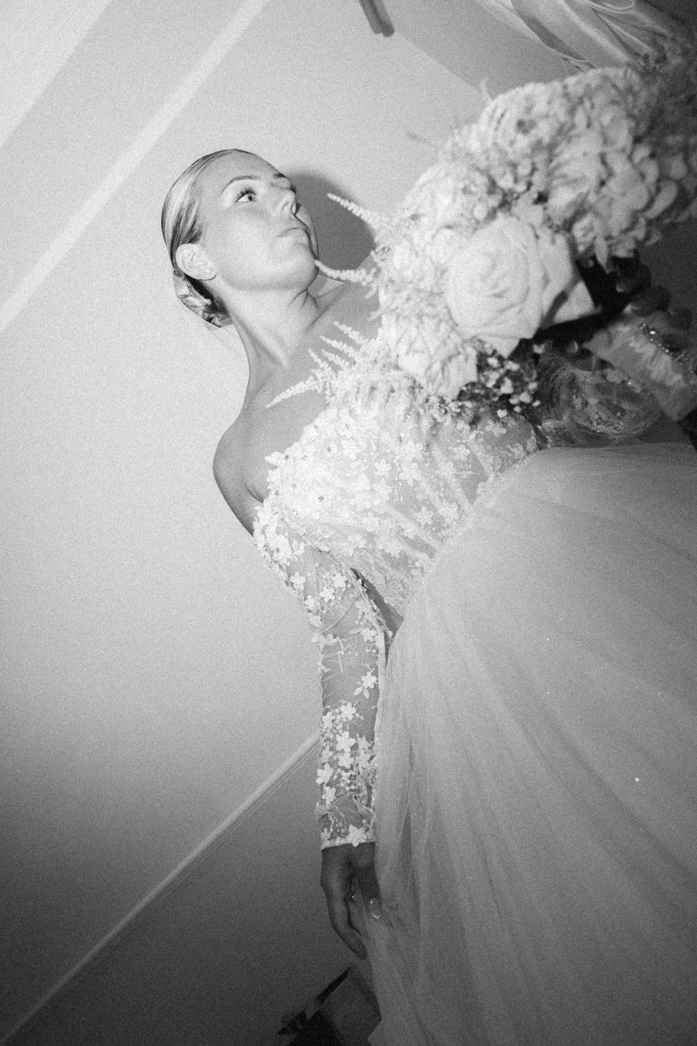 An artistic black and white portrait of someone in a detailed lace wedding gown.