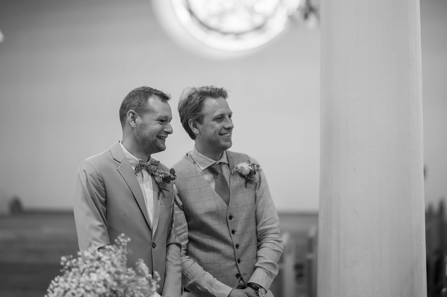 A black and white photograph of two people at an outdoor wedding ceremony with a glowing full moon above in the evening sky.