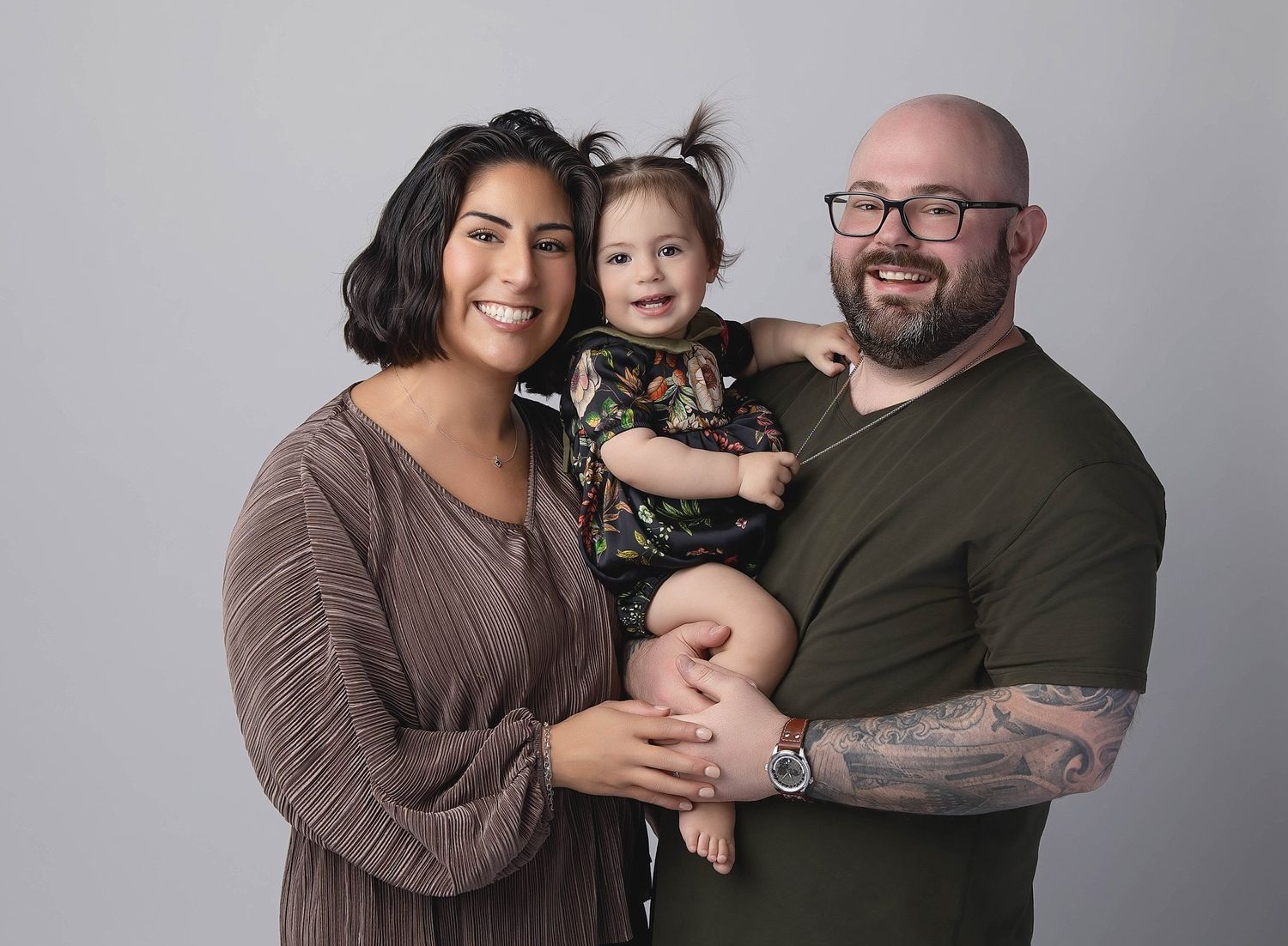 Austin family photography studio portrait of parents holding toddler on neutral gray background
