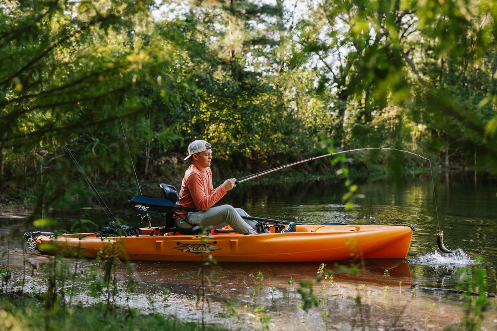 Kayaker paddling through calm waters surrounded by lush greenery.