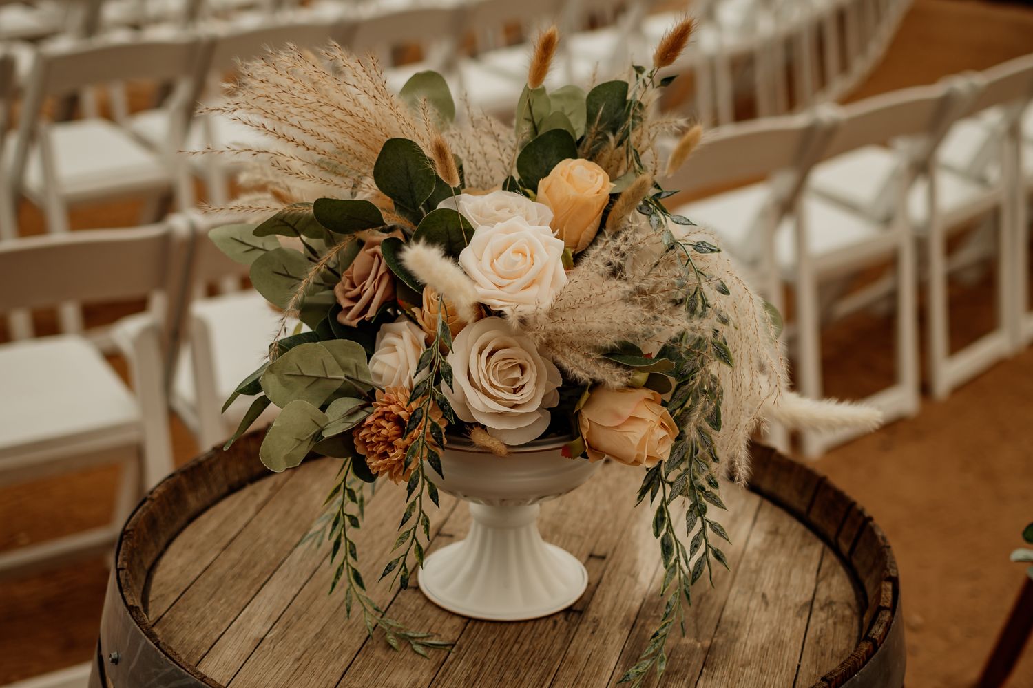 flower centerpiece with chairs in the background.