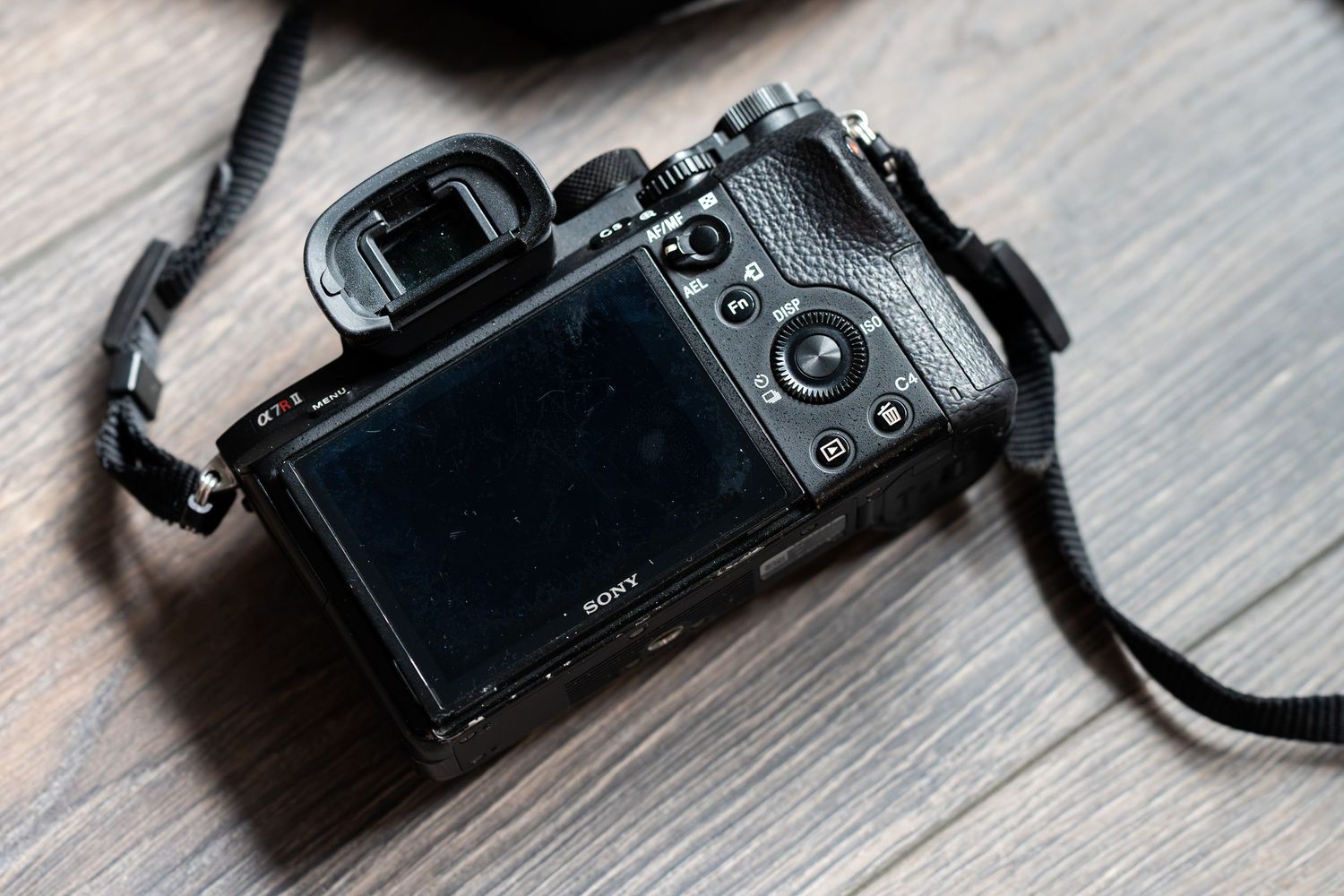 Professional camera equipment including lenses and camera bodies arranged on a gray wooden surface.