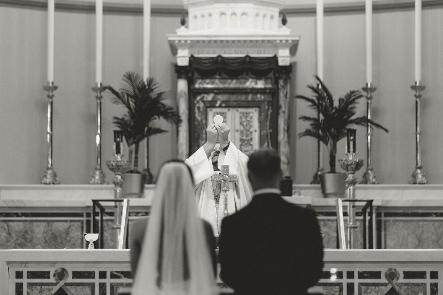 Sacred Heart Cathedral Catholic wedding ceremony, priest holding communion host, Knoxville TN wedding photography