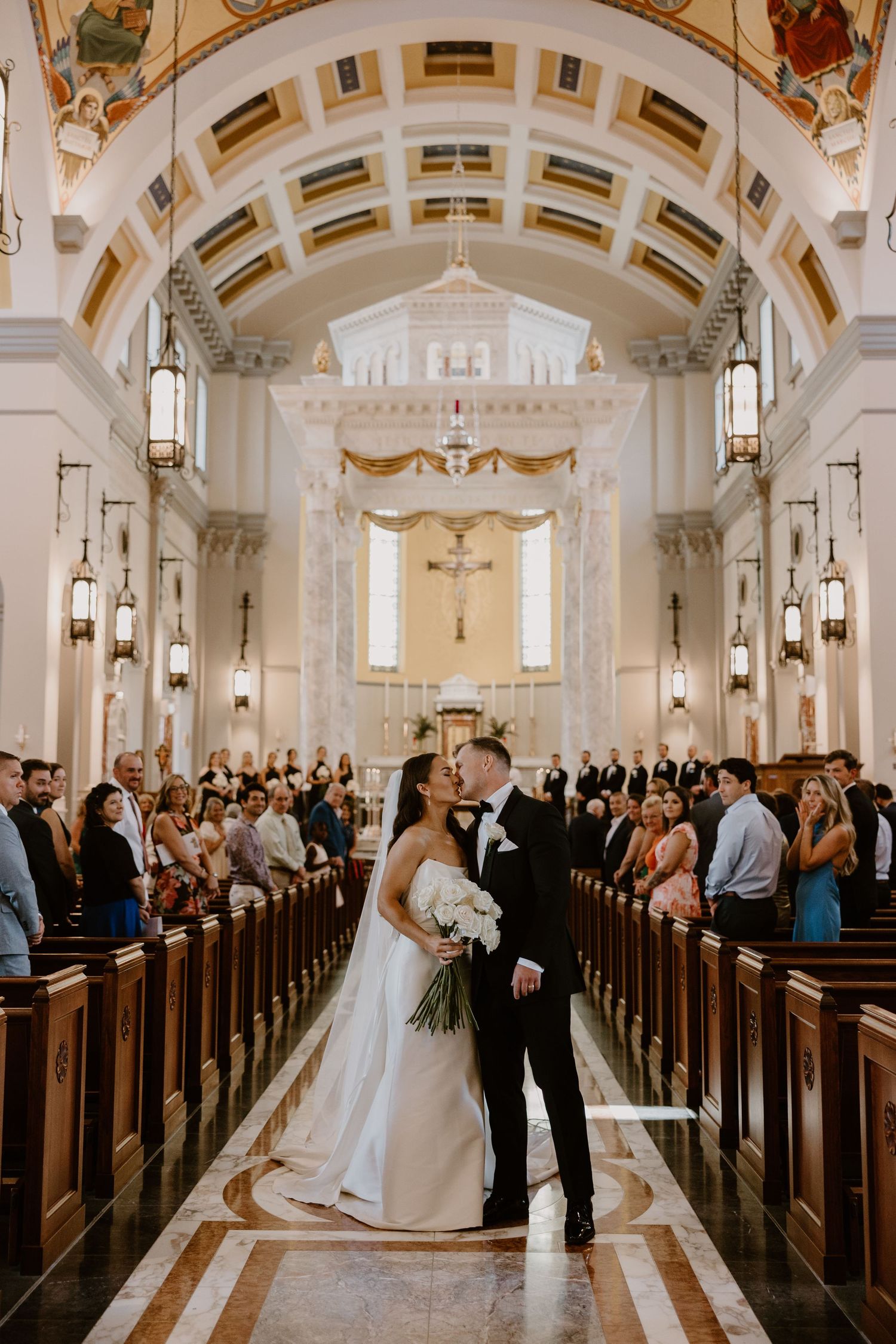 Bride and groom first kiss at altar of Sacred Heart Cathedral, Knoxville TN Catholic wedding photography