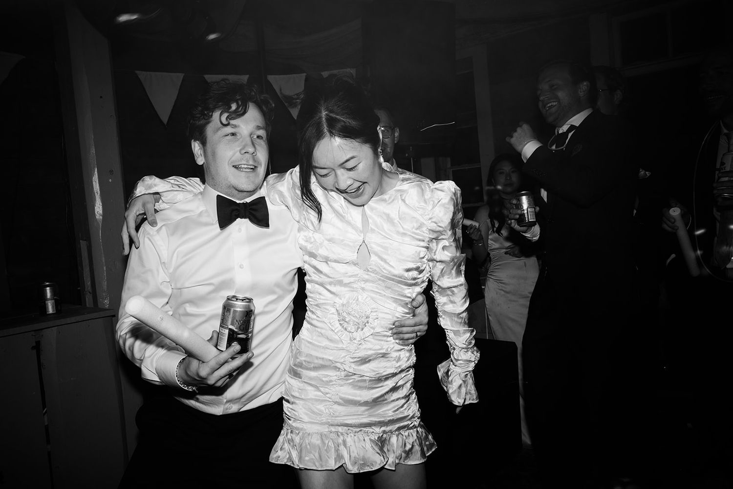 A black and white photo series shows people dancing and celebrating at what appears to be a wedding reception or party.