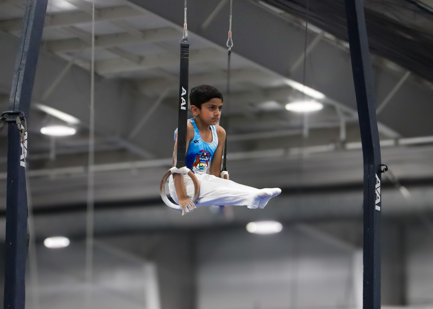 Action sports portrait of an athlete, midair inside a gym, captured during a lifestyle photography session in Michigan