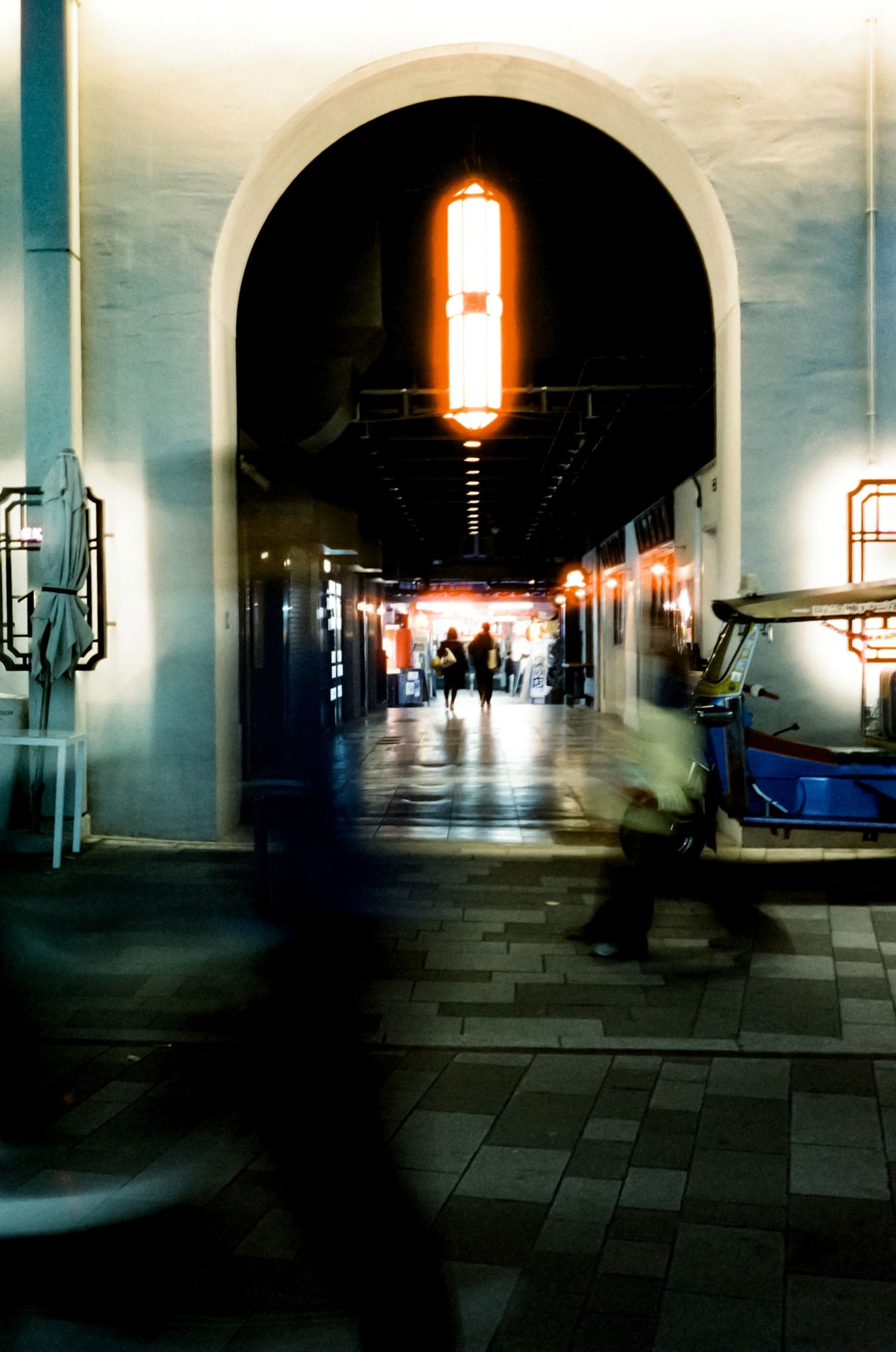 A dark tunnel-like hallway with arched ceilings and warm glowing lights creates an atmospheric architectural perspective.