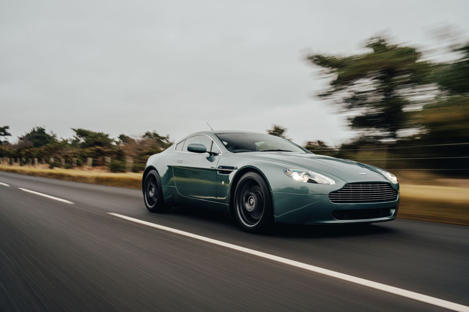 Luxury sports cars driving on winding road with motion blur effect.
