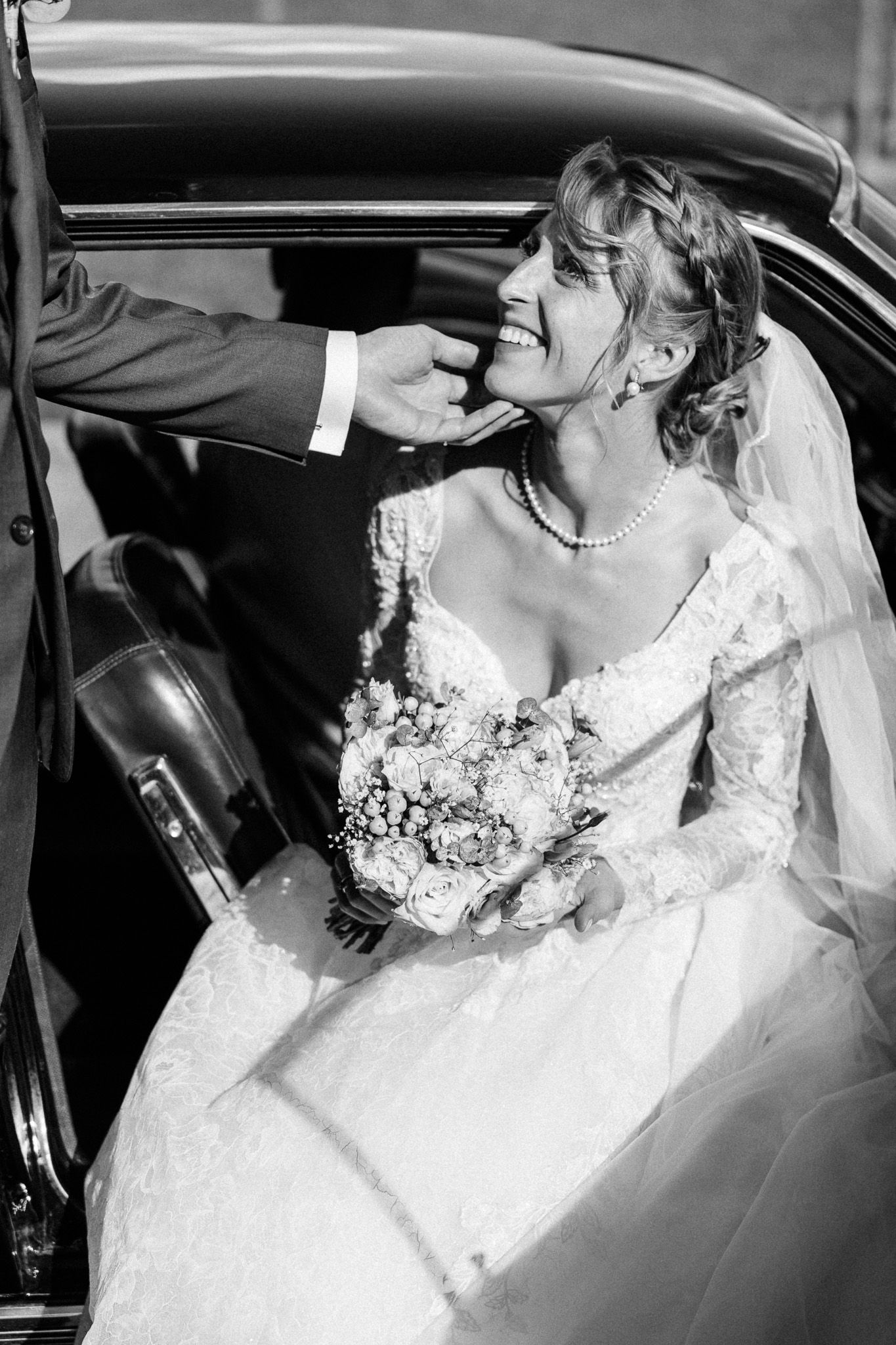 Reportage photo mariage Lille : geste tendre du marie vers la mariee lors de leur arrivee au chateau du Biez.