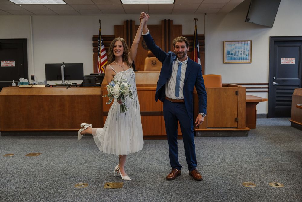 Full-length view of a courthouse wedding ceremony with autumn leaves scattered on the floor.