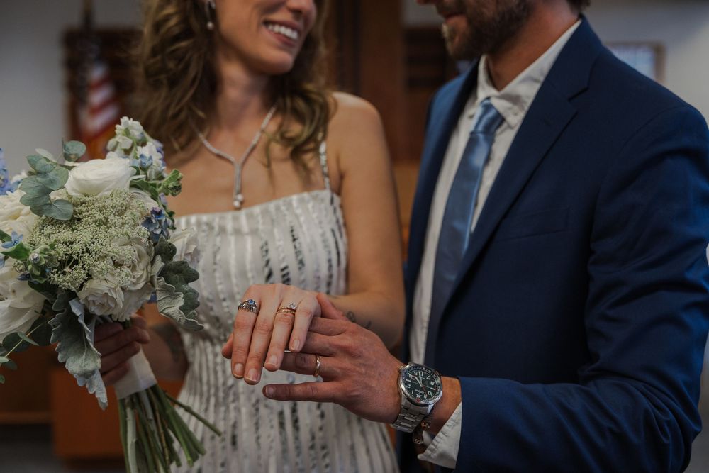Joyful couple shows off their wedding rings after the ceremony.