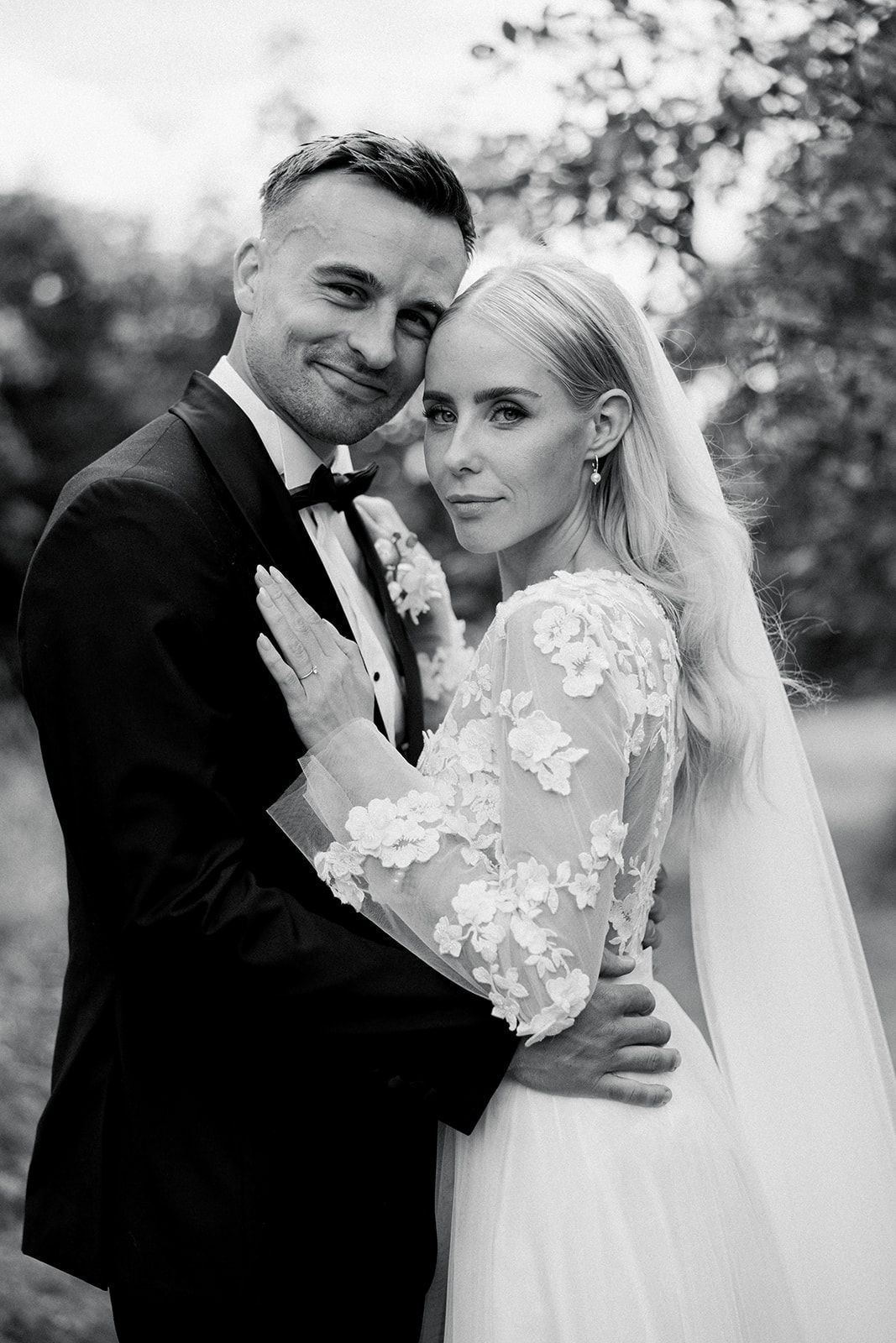 Black and white wedding portrait series showing intimate moments between newlyweds in an outdoor garden setting.