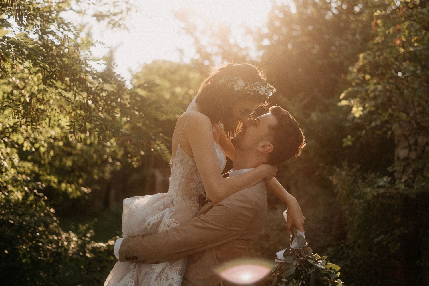 A romantic sunset wedding photo session in a lush garden setting with golden sunlight filtering through the trees.