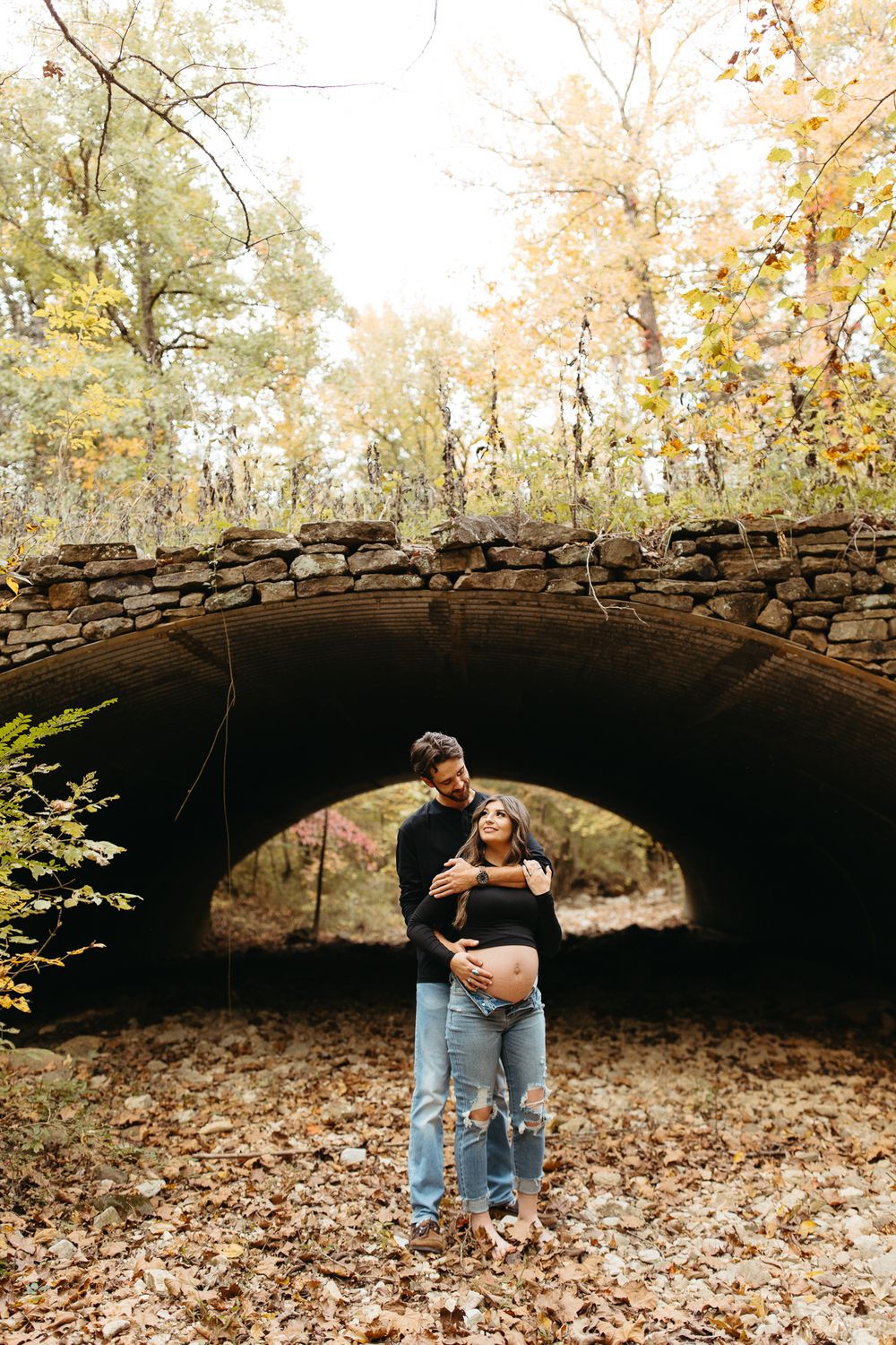 A series of autumn photos showing a person reading under a rustic stone bridge surrounded by fallen leaves.