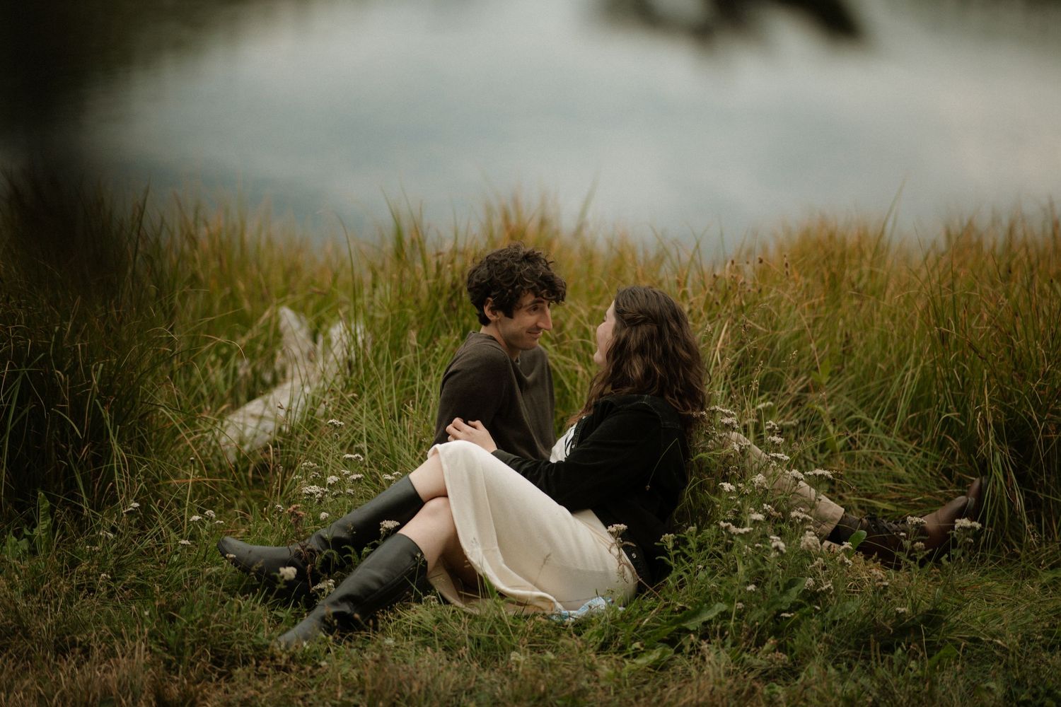 Close-up of hands reaching towards each other in a dreamy outdoor setting.