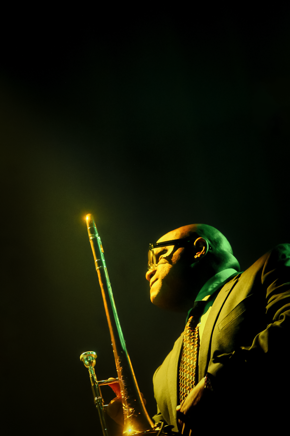 Dramatic lighting illuminates a person in a dark setting holding glowing light sabers against a black background.
