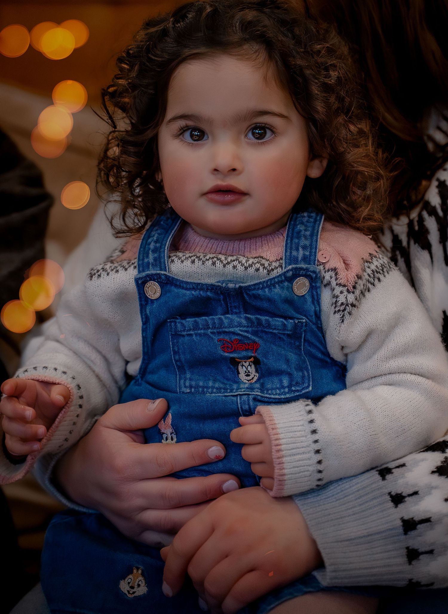 A series of photos showing a child in blue denim overalls and white sweater against a warm bokeh background.