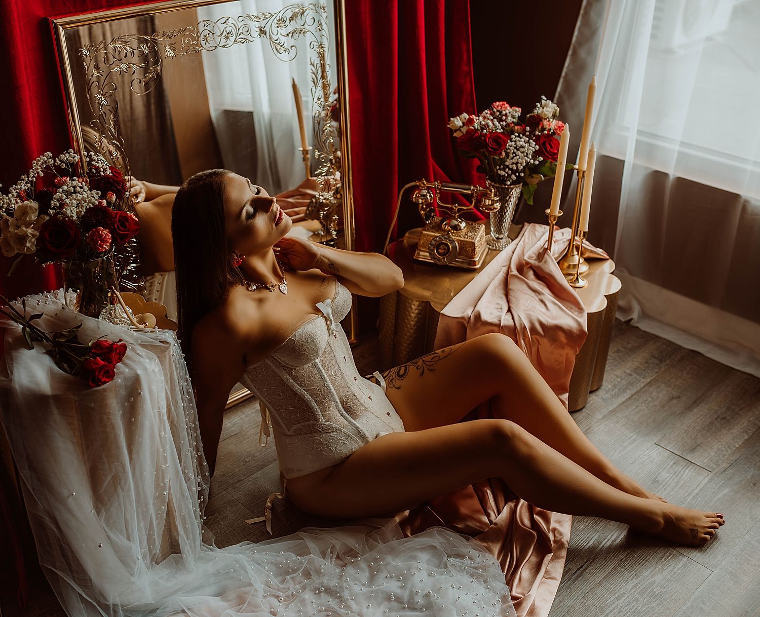 Brunette sits in front of mirror with roses by boudoir photography Wisconsin.