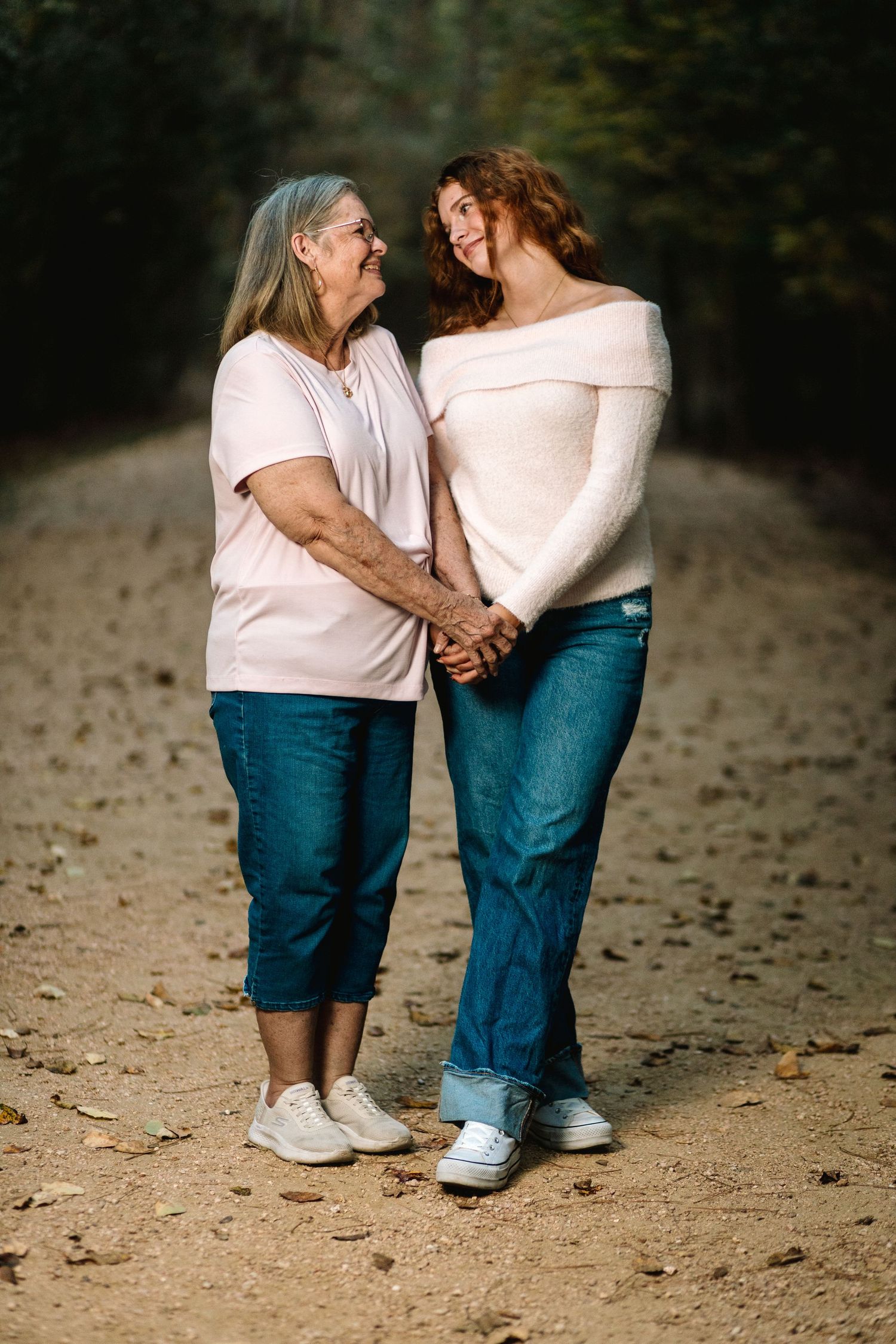 Four progressive photos showing two people in jeans and light tops sharing a tender moment on a dirt path.