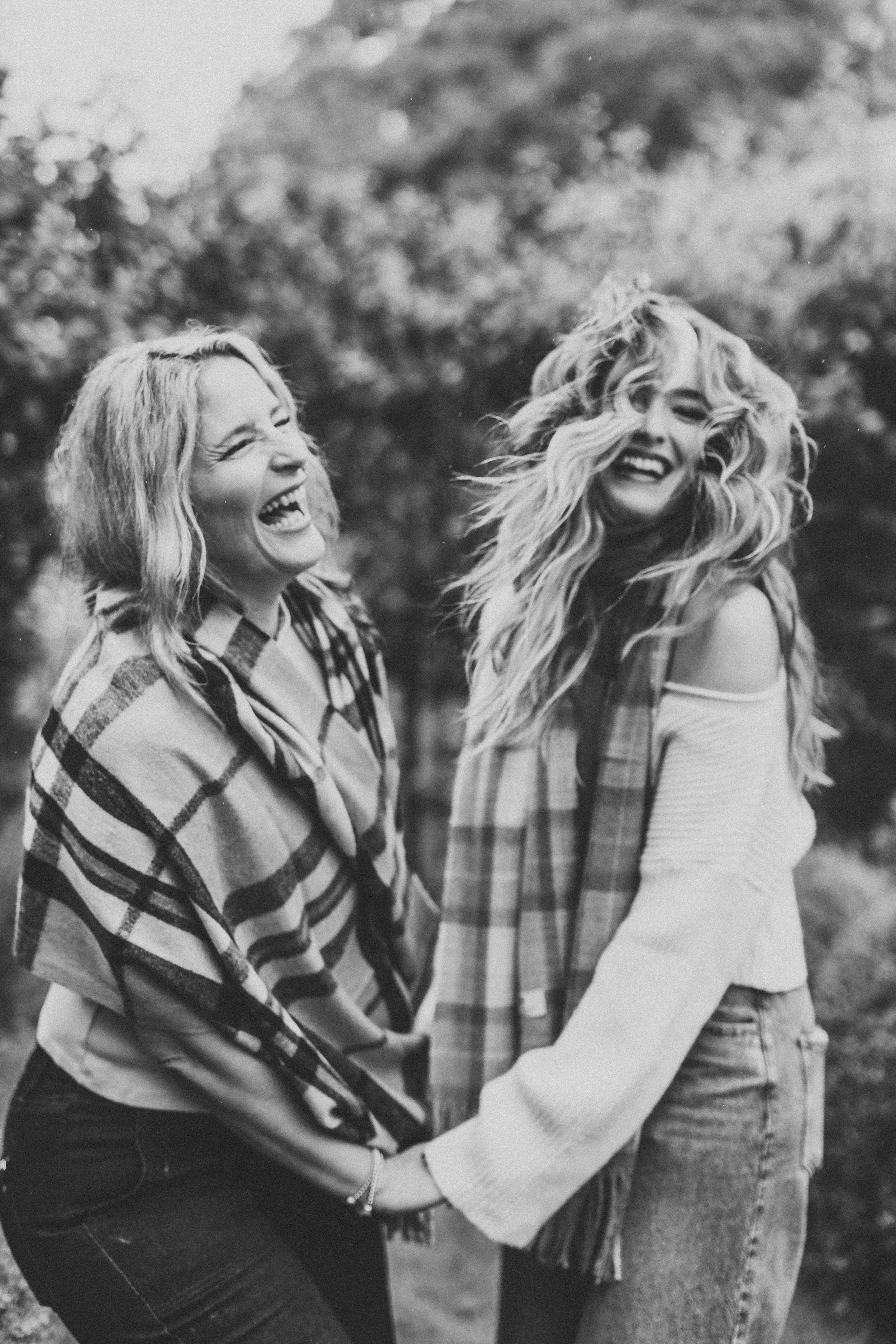 Black and white sequence of candid laughing moments captured in natural outdoor setting showing pure joy and friendship.