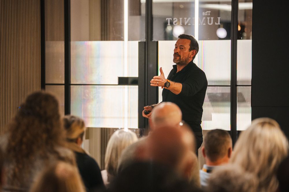 Corporate speaker addressing audience in modern conference venue.