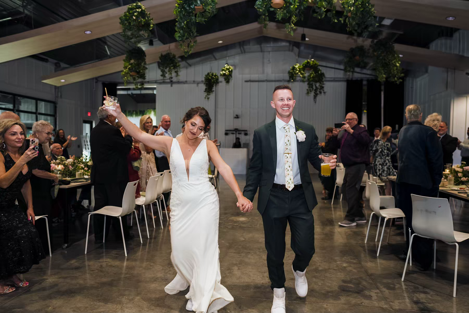 A couple dancing together at a wedding reception in an indoor venue with elegant decor and ambient lighting.
