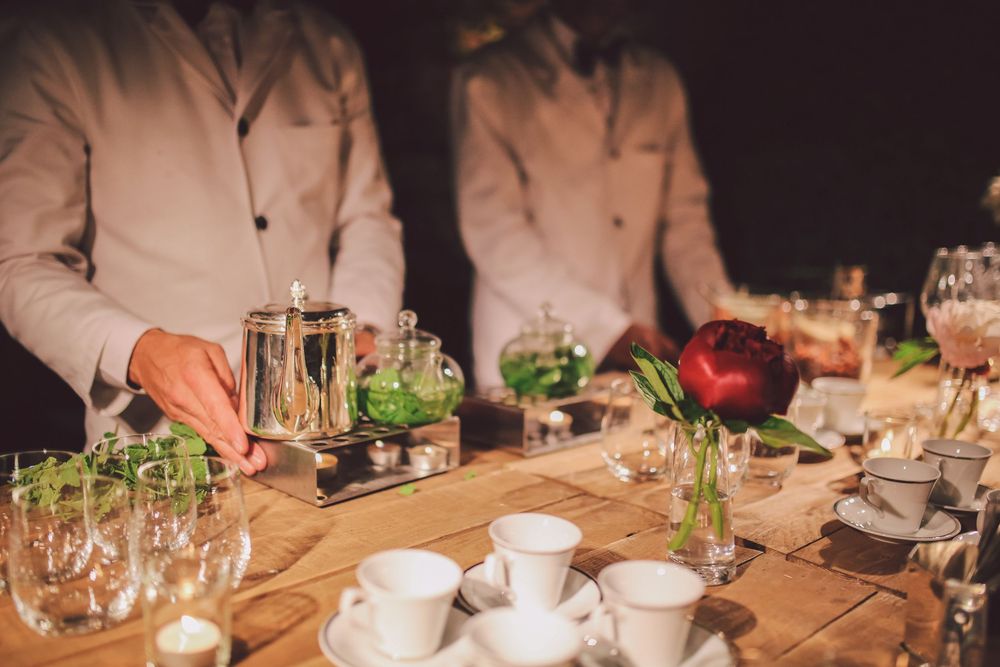 Elegant table settings with wine glasses and candlelight at an upscale dinner party.
