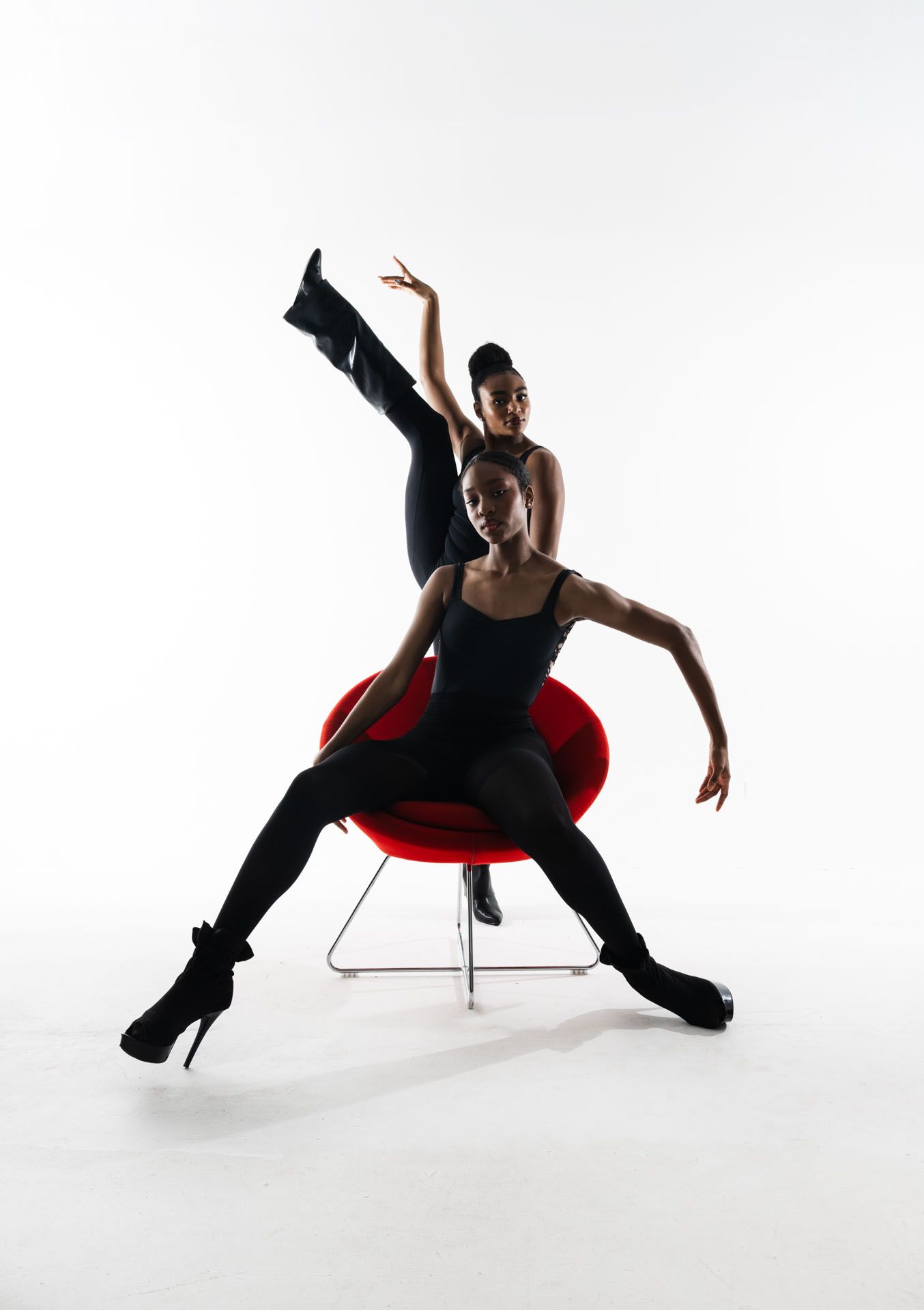 A dancer in black attire performs a dynamic sequence of modern dance movements on a white background.