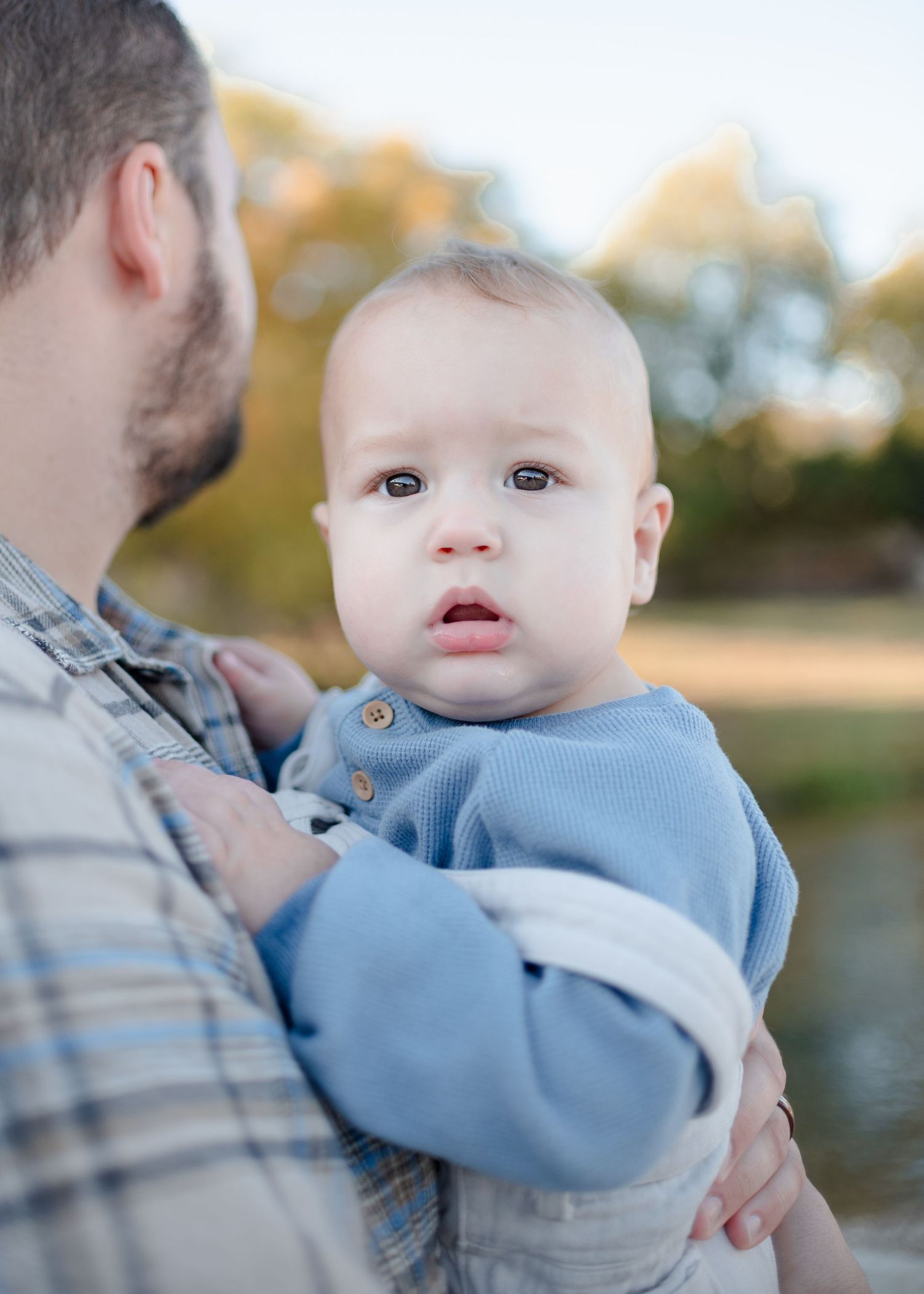 Father holding baby during outdoor family session at Nolan Creek in Belton Texas