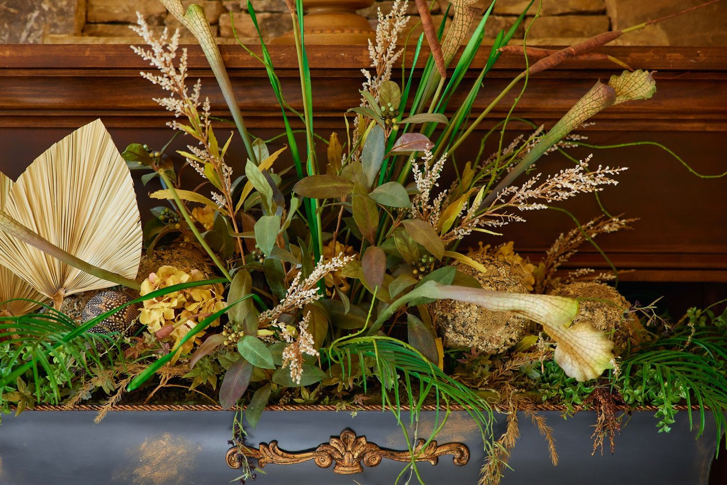Rustic floral arrangement with dried grasses, eucalyptus, and wildflowers displayed in a vintage dark wooden box.