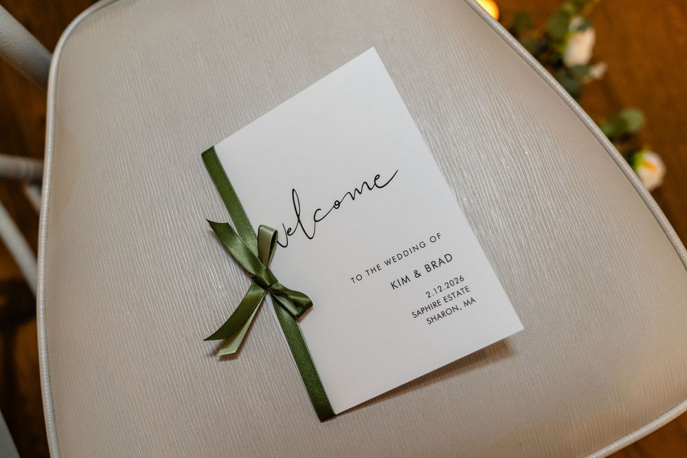 Elegant wedding program with green ribbon bow at The Saphire Estate wedding