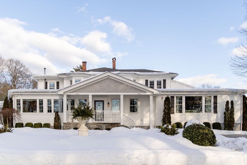 Snow-covered exterior of The Saphire Estate under winter sky in Sharon Massachusetts