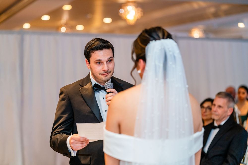 Groom reading vows to bride during elegant indoor ceremony at The Saphire Estate.