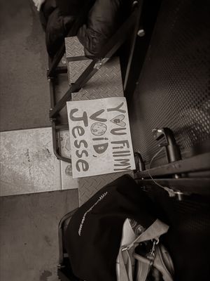 Handwritten fan sign reading You Film Void Jesse on floor near equipment backstage.