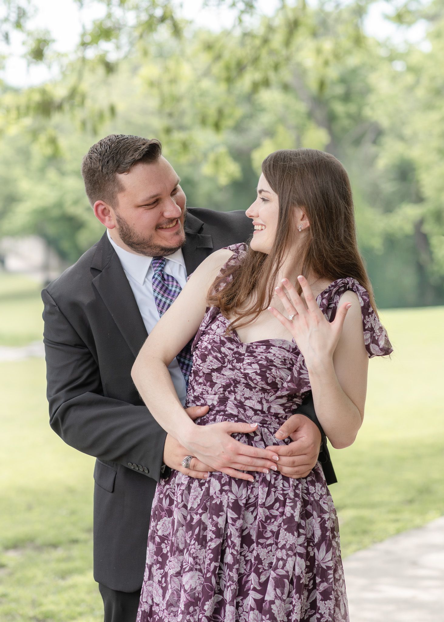 Couple embracing and smiling during engagement photos at Nolan Creek Trail in Temple Texas with soft natural light