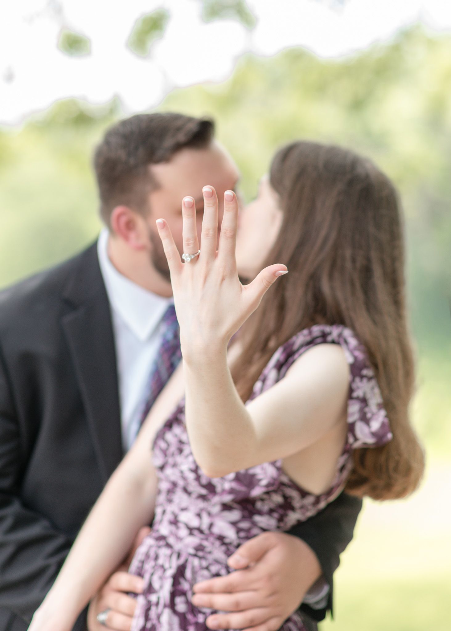 Bride to be showing engagement ring while kissing fiancé during Temple Texas engagement photoshoot