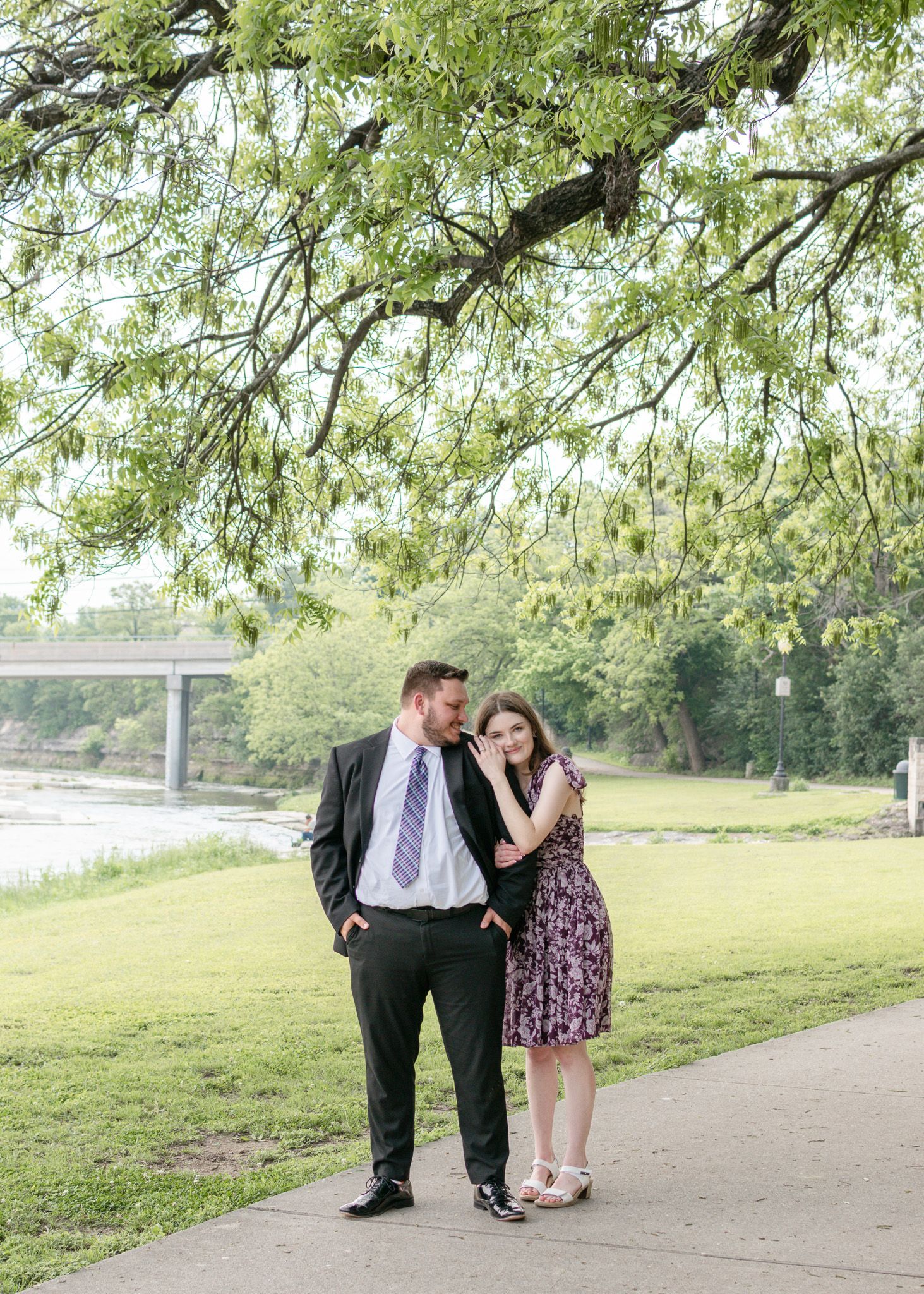 Couple walking together under trees at Nolan Creek Trail in Temple Texas during relaxed engagement session