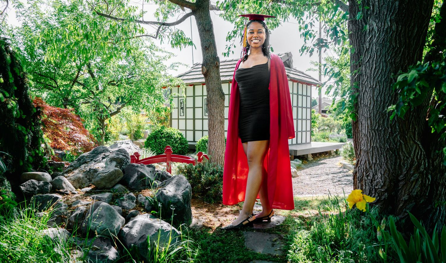 Class of 2026 senior standing in garden during graduation session