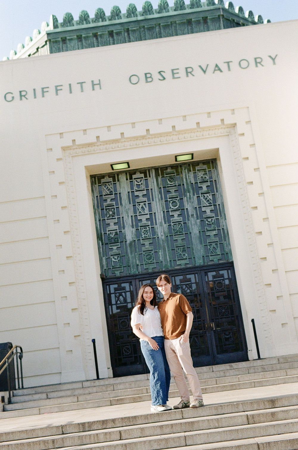 Griffith Observatory architecture in the background of a candid, documentary engagement session for an NC-based film photographer.