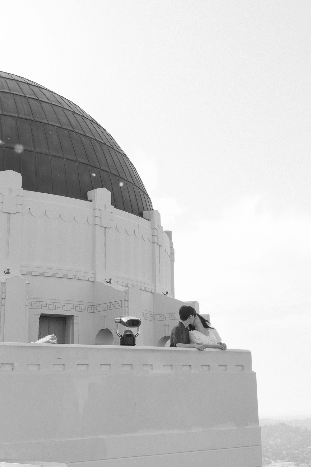 Iconic Griffith Observatory architecture in the background of a candid, documentary engagement session for an NC-based film photographer.