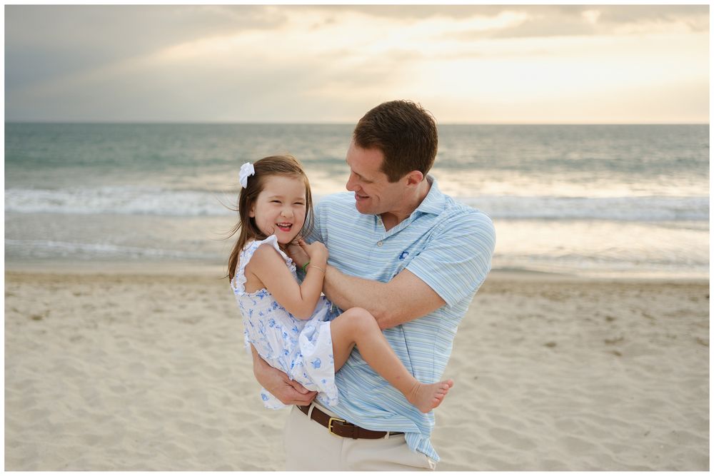 Beach family photos at Villa del Palmar Flamingos of a father laughing with his daughter at sunset.