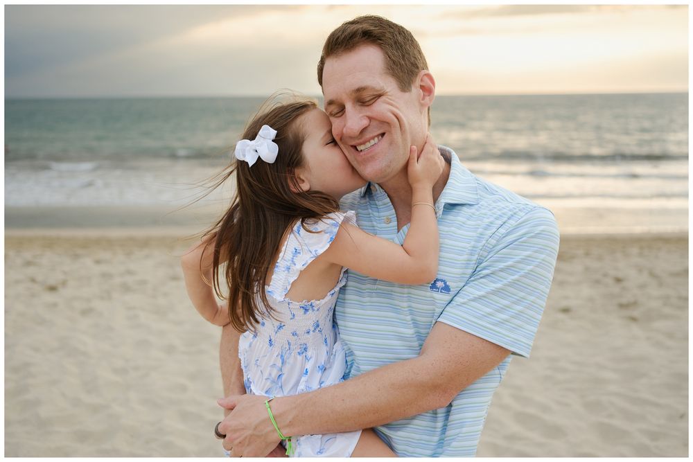 Beach family photos at Villa del Palmar Flamingos of a father holding his daughter during a sunset beach session.