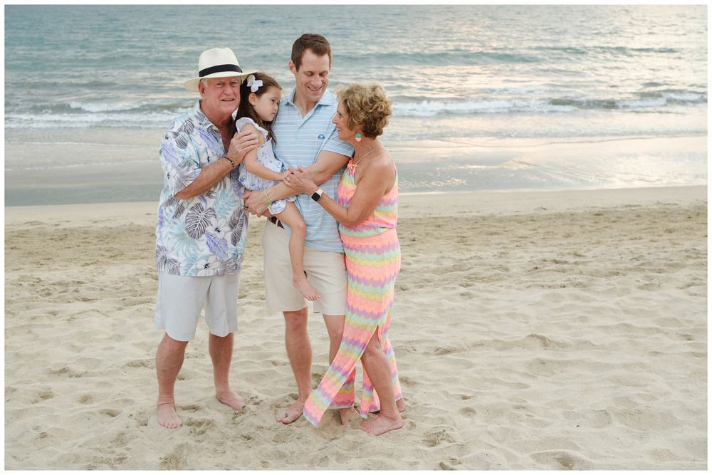 Beach family photos at Villa del Palmar Flamingos of grandparents with their grandchildren sharing a joyful moment at sunset.