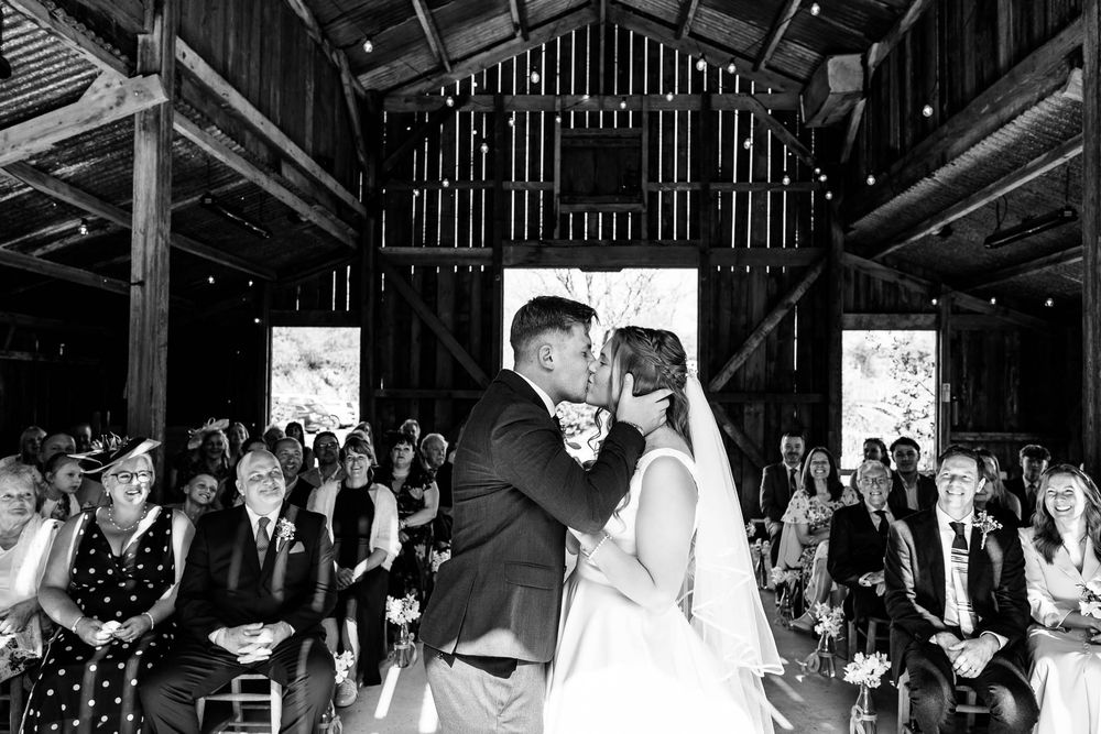 Bride and Groom first kiss rustic Wedding venue in Cornwall