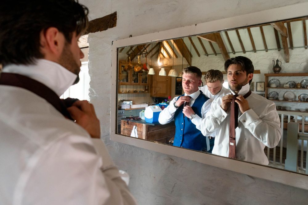 Groom and friends getting ready in mirror at Nancarrow Farm